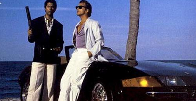 Sometimes a man just likes to hold a sawn-off shotgun while standing beside his parked car and wearing a pink shirt...